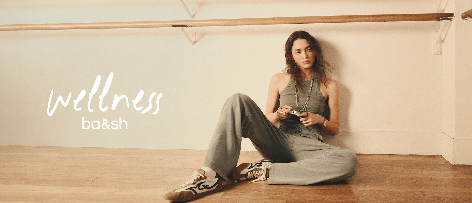 A model wearing a khaki tracksuit in a dance studio