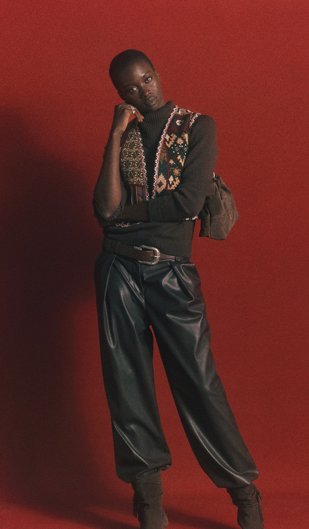 woman wearing an embroidered gilet, a pair of borwn leather trousers