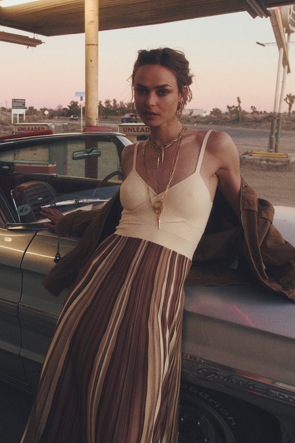 A model next to the car wearing a dress