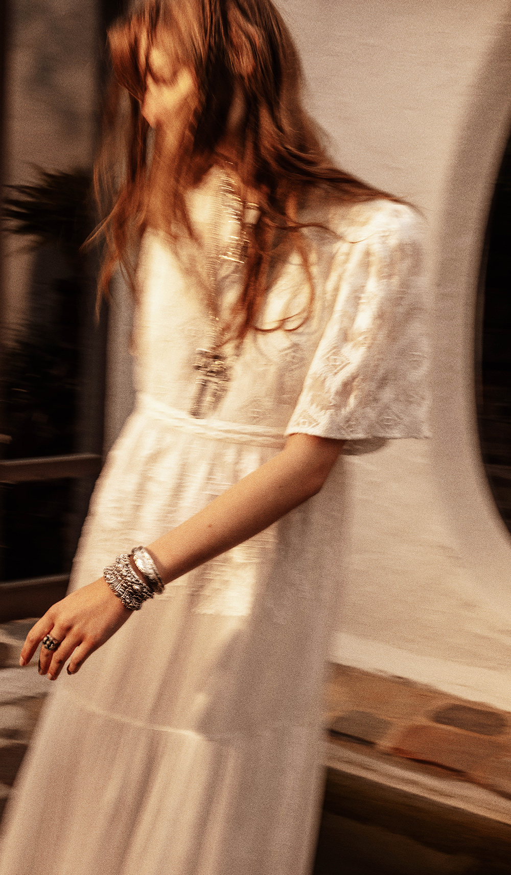 a model wearing an embroidered white maxi dress